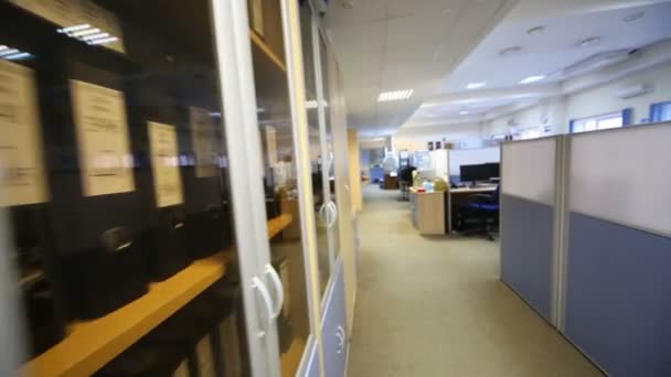Книжкова шафа з документами та людьми на робочих місцях — стокове відео