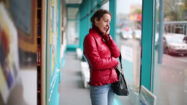 Woman in jacket talking on cell phone. — Stok video