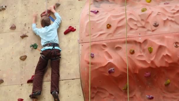 Boy-débutant grimpe sur le mur — Video