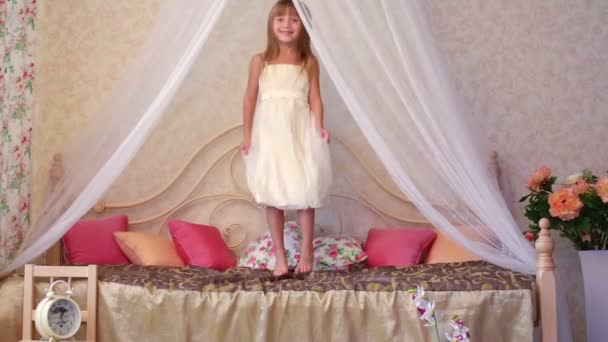 Petite fille sautant sur le lit dans la chambre — Video