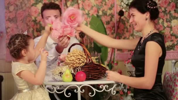 Famille assise à table avec des fleurs — Video