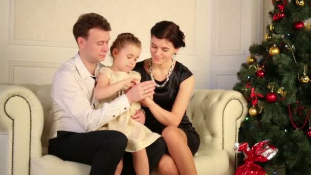 Father, mother and daughter sit on sofa — Stock Video