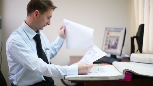Homem folheando documentos com esquemas — Vídeo de Stock