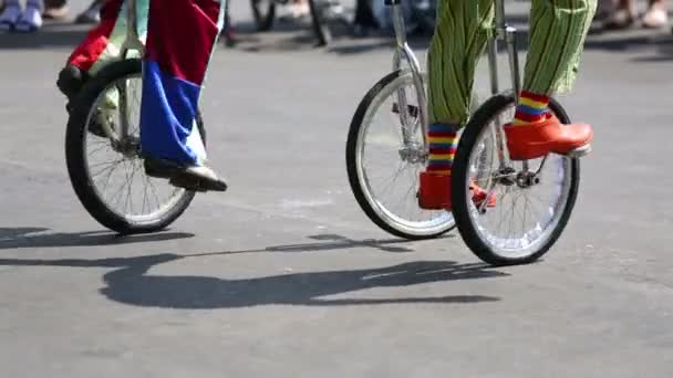 Pieds de clowns chevauchant sur des monocycles en plein air — Video