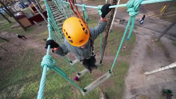 Boy in helmet swings at rope way — Stock Video