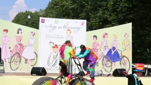 Клоуны на большом велосипеде на велопараде — стоковое видео
