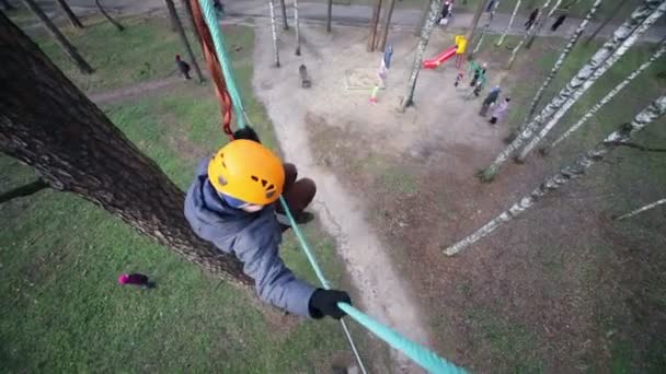 Junge mit Helm klettert an Seilbahn — Stockvideo