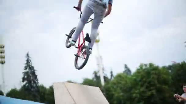 エキシビションセンターで自転車に飛び乗る少年 — ストック動画