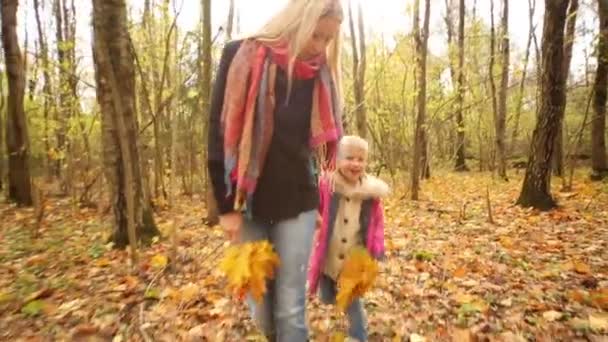 Kleine Tochter und Mutter im Herbstwald — Stockvideo