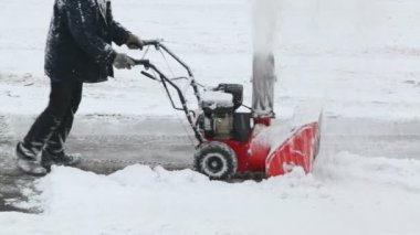 Worker removes snow on parking
