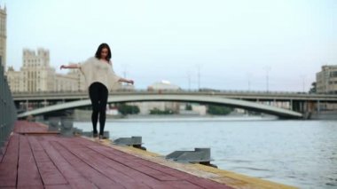 Woman walks along wooden waterfront