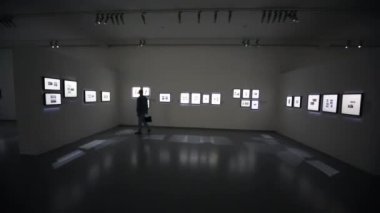 Adam yürümek ve sergide fotoğraflara bakmak