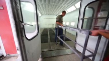 İşçiler kabini boyamak için çerçeve getiriyorlar