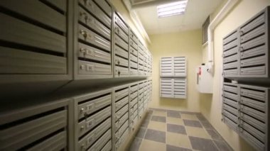 Duvarlarda posta kutuları olan koridor