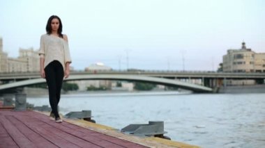 Woman walks along wooden waterfront
