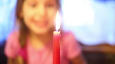 Küçük kız mum üfler