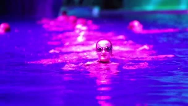 Синхронные пловцы выступают в бассейне — стоковое видео