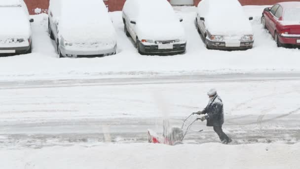 Worker removes snow near cars — Stock Video