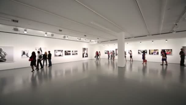 La gente camina en la gran sala de exposiciones — Vídeos de Stock