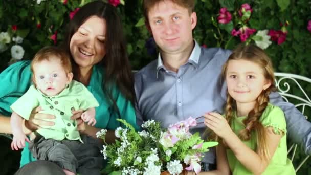 Familia sentarse en el banco del jardín — Vídeos de Stock