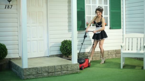 Smiling housemaid mows lawn — Stock Video