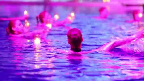 Synchronized swimmers with burning candles performs — Stock Video