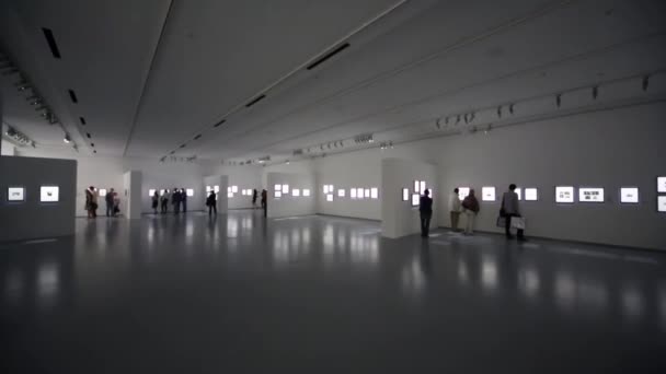 Les gens regardent des photos à l'exposition — Video