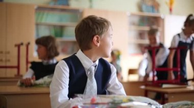 Okul çocuğu sınıfta masasında oturuyor