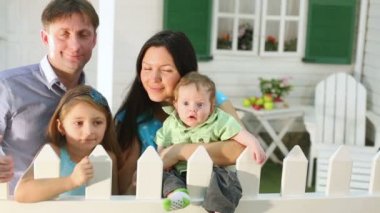 Mutlu aile beyaz çitin yanındaki