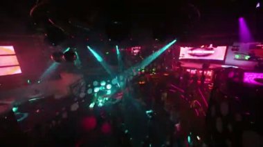 Gençler gece kulübünün dans pistinde dans eder.