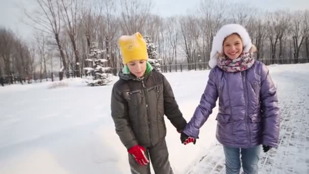 Брат і сестра біжать по стежці в парку — стокове відео