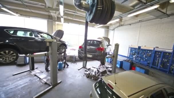 Cars for repairing on lifts and floor — Stock Video