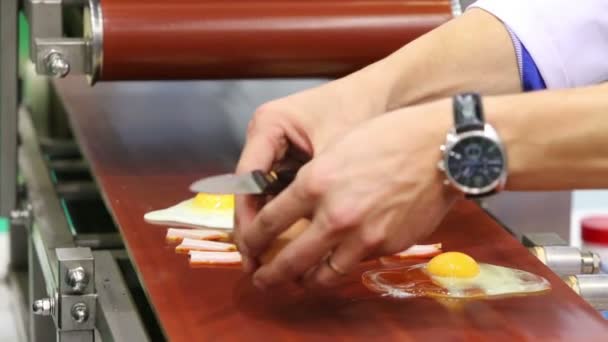 Руки разбивают яйца и откладывают бекон — стоковое видео