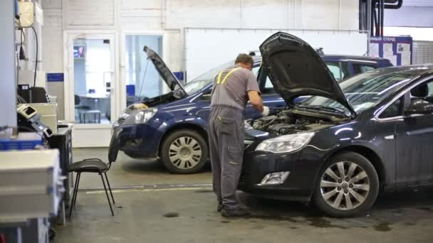 Monteur in overalls geopend motorkap van auto — Stockvideo