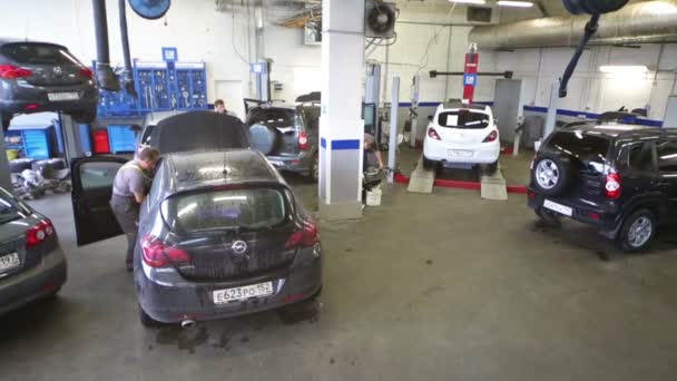 Trabajadores reparando levantar coches en el taller — Vídeos de Stock