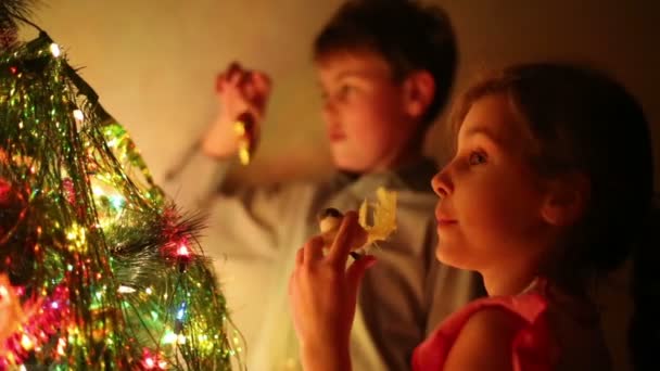 Niño y niña decorar árbol de Navidad — Vídeos de Stock