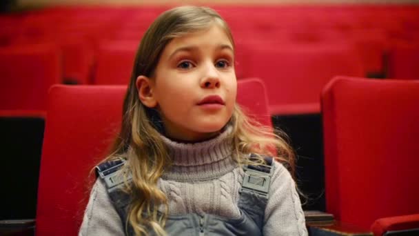 Girl sits on red chair and smiles — Stock Video