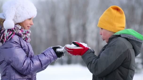 Junge und Mädchen werfen Schnee — Stockvideo