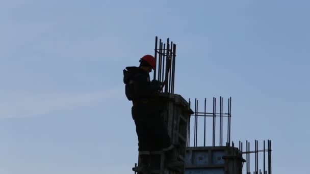 Silhouette del costruttore installa barra di rinforzo sulla costruzione — Video Stock