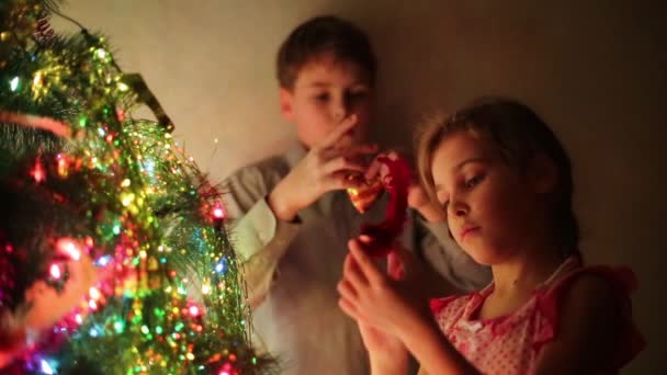 Junge und Mädchen schmücken Weihnachtsbaum — Stockvideo