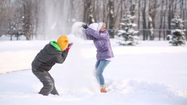 Boy and girl throw snow — Stock Video