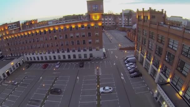 Plaza de aparcamiento entre edificios con iluminación — Vídeos de Stock