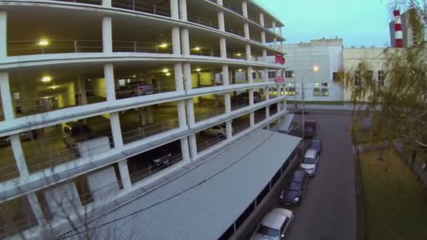 Bilar åka av vägen nära multilevel garage — Stockvideo