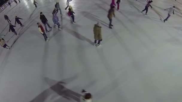 Młodzi ludzie na łyżwach na lodowisku — Wideo stockowe