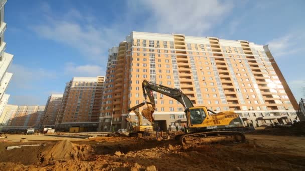 Excavator digs ground near building — Stock Video