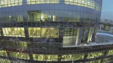 İnsanlar pencerelerin arkasındaki ofislerde çalışırlar.