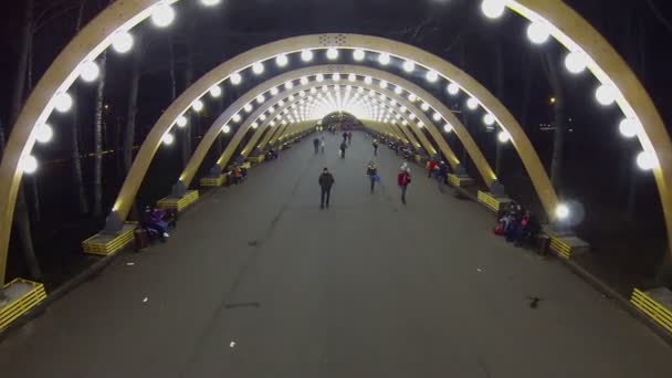 Citizens walk under illuminated arcs — Stock Video