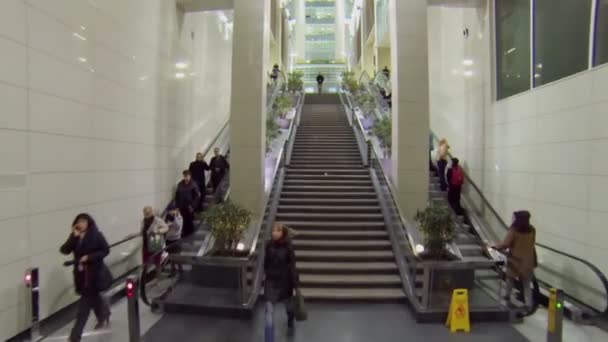 Ludzie jeżdżą przez schody ruchome — Wideo stockowe
