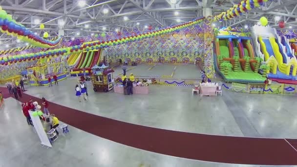 Mensen lopen door kinderachtig amusement gebied — Stockvideo