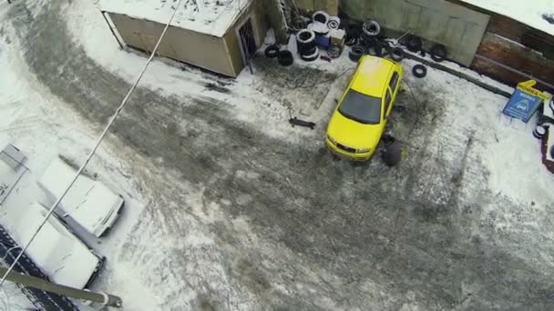 Schroeven voor arbeiders op wielen van gele auto — Stockvideo
